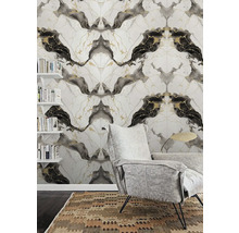 Moderní obývací pokoj s vliesovou tapetou se vzhledem mramoru, šedým křeslem a nástěnnými policemi s knihami.