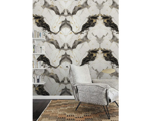 Moderní obývací pokoj s vliesovou tapetou se vzhledem mramoru, šedým křeslem a nástěnnými policemi s knihami.