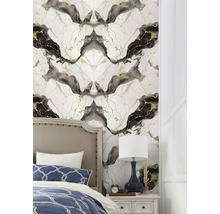Tapeta s mramorovým vzorem s černými a zlatými žilami za čalouněnou postelí ve světlé ložnici.
