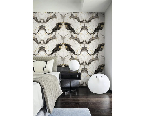 Ložnice s vliesovou tapetou s mramorovým vzorem v černé a zlaté barvě, postel s šedým povlečením a kulaté bílé lampy.