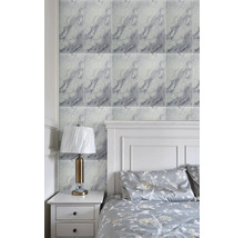 Obklady na stěnu s mramorovým vzhledem ve světlé ložnici s bílou postelí a nočním stolkem.