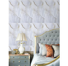 Ložnice s tapetou ve vzhledu mramoru se zlatými žilkami, prošívaným čelem postele, nočním stolkem a klasickou stolní lampou.