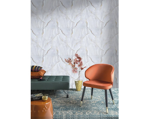 Nástěnné obklady v bílém mramorovém vzhledu se zlatým žilkováním v moderním obývacím pokoji s oranžovým křeslem a zeleným taburetem.