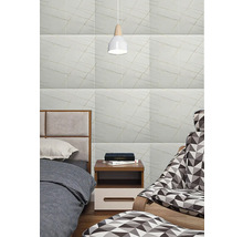 Obklady s jemným liniovým vzorem ve světlé ložnici s postelí, nočním stolkem a vzorovaným křeslem.