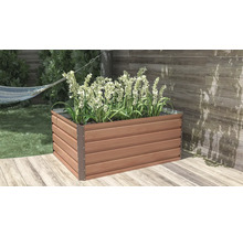 Obdélníkový vyvýšený záhon s dekorem dřeva a kovovými rohy, osázený bílými květinami na dřevěné terase.