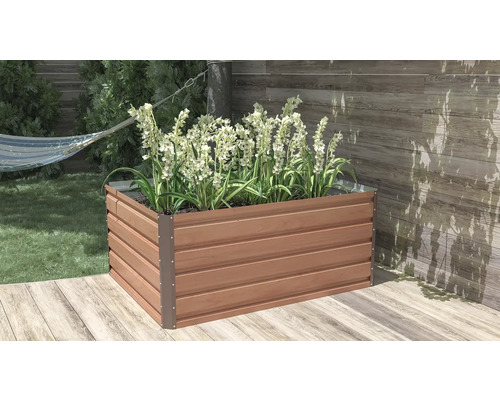 Obdélníkový vyvýšený záhon s dekorem dřeva a kovovými rohy, osázený bílými květinami na dřevěné terase.