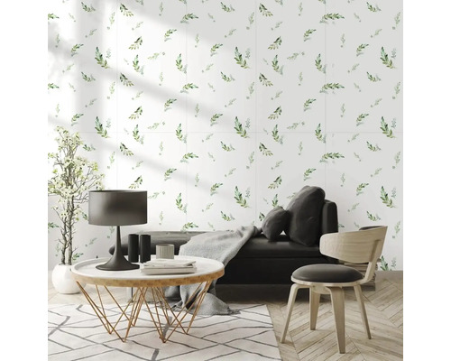 Moderní, světlý obývací pokoj s tapetou s motivem listů, tmavou pohovkou, kulatým konferenčním stolkem a parketami ve vzoru rybí kosti.