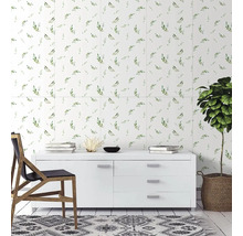 Světlé nástěnné obklady se vzorem zelených listů za bílou komodou v moderním, uklizeném obývacím pokoji s dřevěnou židlí a pokojovou rostlinou.