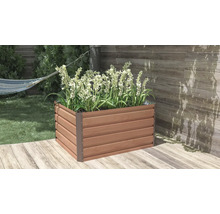 Obdélníkový vyvýšený záhon v dekoru dřeva na světlé terase, osázený vysokými bílými květinami. Uspořádaná zahradní scéna s dřevěnou podlahou a stěnou.