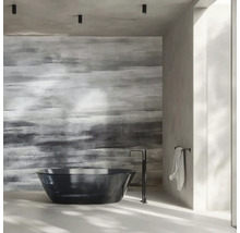 Moderní koupelna s volně stojící černou vanou, podlahovou baterií a strukturovanou akcentní stěnou v šedé barvě.