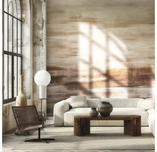 Fototapeta s abstraktními tahy štětcem v zemitých tónech ve světlém obývacím pokoji s bílou pohovkou a masivním dřevěným stolem.