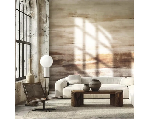 Fototapeta s abstraktními tahy štětcem v zemitých tónech ve světlém obývacím pokoji s bílou pohovkou a masivním dřevěným stolem.