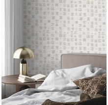 Vliesová tapeta s jemným kostkovaným vzorem v ložnici s postelí, dřevěným odkládacím stolkem a zlatou stolní lampou.