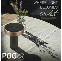 Solární stolní lampa POGA na zahradním stole s ubrusem vedle skleněné vázy s květinami.