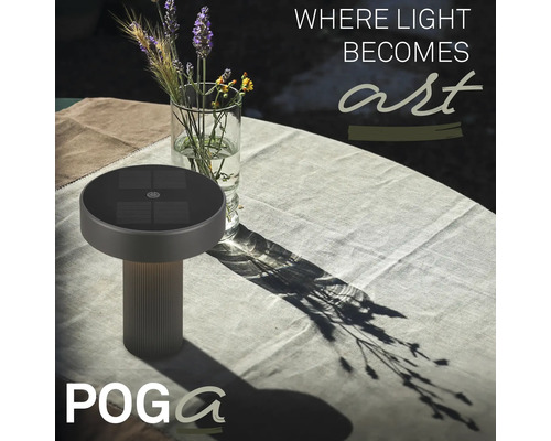 Solární stolní lampa na světlém, prostřeném zahradním stole s vázou květin a Poga Logo.