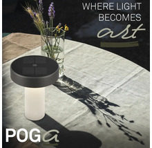 Solární stolní lampa Poga s drážkovaným podstavcem na prostřeném zahradním stole vedle vázy s květinami.