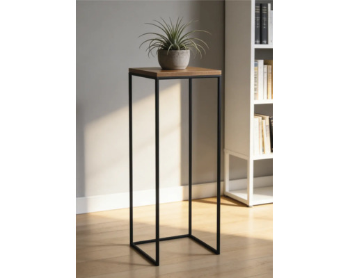 Moderní stojan na květiny s černým kovovým rámem a dřevěnou deskou, s rostlinou v květináči ve světlé místnosti s knihovnou.