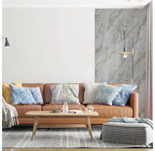 Moderní obývací pokoj s hnědou koženou pohovkou, dřevěným stolkem a vliesovou tapetou se vzhledem mramoru a zlatými akcenty.