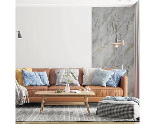 Moderní obývací pokoj s hnědou koženou pohovkou, dřevěným stolkem a vliesovou tapetou se vzhledem mramoru a zlatými akcenty.