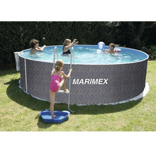 Kruhový nadzemní bazén s ratanovým vzorem, schůdky a vaničkou na nohy na zahradě s hrajícími si dětmi.