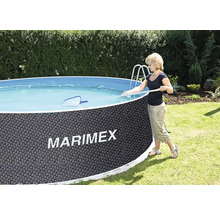 Kulatý nadzemní bazén v tmavě šedém ratanovém dekoru s logem Marimex na zahradě, osoba čistí vodu hladinovou síťkou.