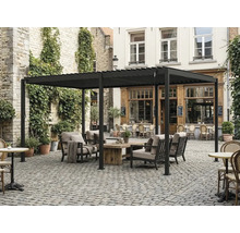 Volně stojící hliníková pergola s lamelovou střechou, zahradní nábytek s dřevěným stolem na dlážděném dvoře.