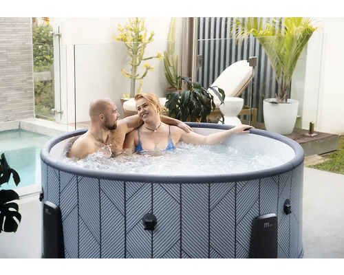 Nafukovací vířivka s geometrickým vzorem na světlé terase s rostlinami a párem.