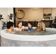 Rodina relaxuje v kulaté nafukovací vířivce s bublající vodou v útulném interiéru.