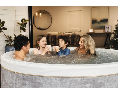 Rodina relaxuje v kulaté nafukovací vířivce s bublající vodou v útulném interiéru.