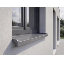 Venkovní hliníkový parapet instalovaný na omítnuté fasádě pod oknem.