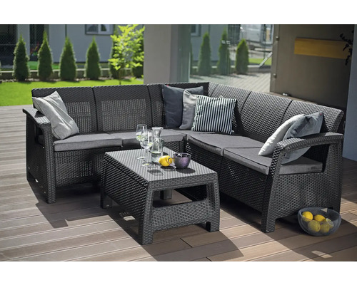 Zahradní lounge set z antracitové rohové pohovky v ratanovém vzhledu a nízkého stolku na dřevěné terase.