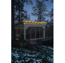 LED světelný déšť s teplým bílým světlem na moderním zahradním domku v zimním nočním prostředí.