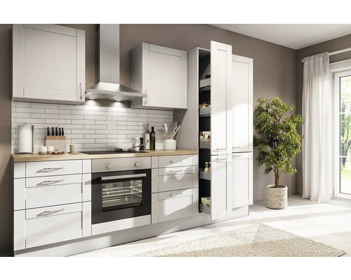 Moderní světlá kuchyně s bílými čely, dřevěnou pracovní deskou, troubou, digestoří a výsuvnou potravinovou skříní.