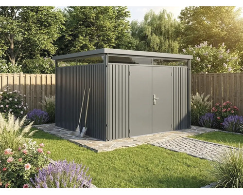 Moderní šedý kovový zahradní domek s plochou střechou a světlíky ve světlé, upravené zahradě s kamennou cestou a záhony.