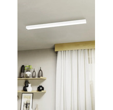 Moderní stropní LED svítidlo v plochém obdélníkovém tvaru namontované na světlém stropě v jasném obývacím pokoji s policemi a závěsy.