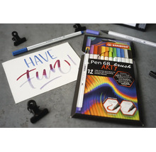Stabilo Pen 68 brush ARTY sada 12 prémiových fixů s flexibilním štětcovým hrotem na šedém podkladu s letteringovou kartou.
