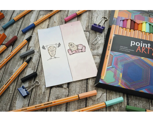 Kreativní scéna s několika finelinery Stabilo Point 88, otevřenou sadou Point Art a kresbou na dřevěném povrchu.