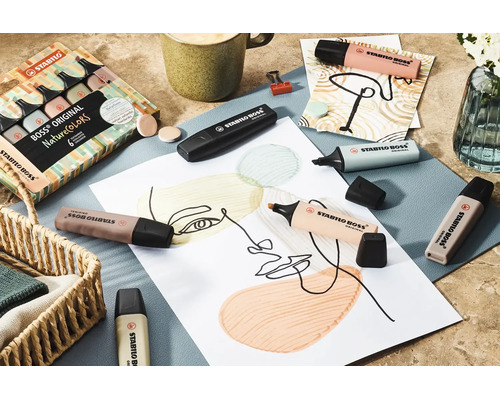 Jasná a uspořádaná scéna se zvýrazňovači Stabilo Boss Original NatureColors v přírodních tónech na kresbě, s výtvarnými potřebami a kávou.