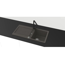 Antracitový vestavný dřez z kompozitního materiálu s odkapávací plochou a černou kuchyňskou baterií.