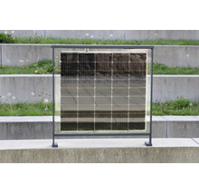 Poloprůhledný solární modul v tmavě šedém kovovém rámu pro balkon nebo plot, stojící na betonovém povrchu.
