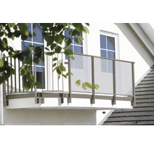 Moderní balkon na bílé fasádě domu se zábradlím z kovových prvků a skleněných výplní.