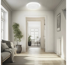 Kruhové stropní LED svítidlo s hvězdným efektem ve světlém, moderně zařízeném obývacím prostoru s výhledem na chodbu.