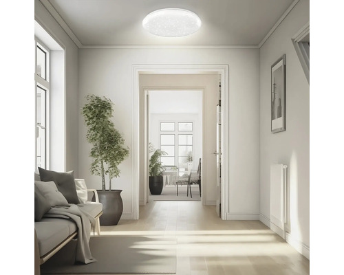 Kruhové stropní LED svítidlo s hvězdným efektem ve světlém, moderně zařízeném obývacím prostoru s výhledem na chodbu.