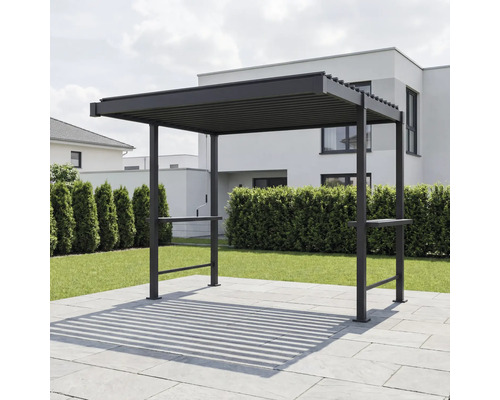 Moderní tmavá kovová pergola s lamelovou střechou na dlážděné terase v zahradě před živým plotem a rodinným domem.