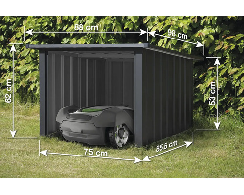 Robotická sekačka v kovové garáži s rozměry: šířka 88 centimetrů, hloubka 98 centimetrů a výška 62 centimetrů.