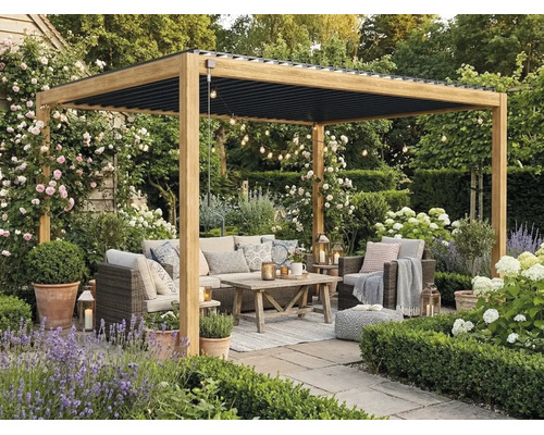Dřevěná pergola s černou lamelovou střechou na terase. S ratanovým nábytkem, dřevěným stolem a zahradními rostlinami jako levandule a růže.