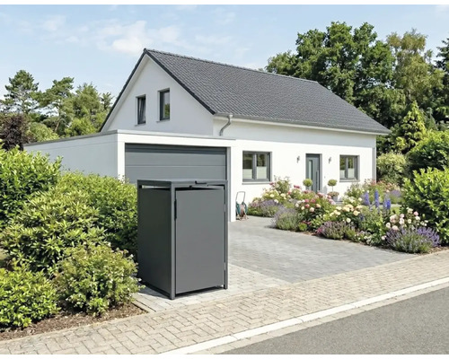 Kovový kryt na popelnice před světlým rodinným domem s garáží, květinovou zahradou a dlážděnou příjezdovou cestou.