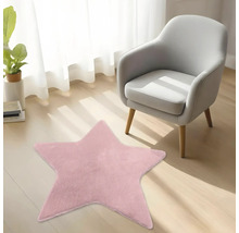 Růžový plyšový koberec ve tvaru hvězdy na dřevěné podlaze vedle moderního křesla ve světlém pokoji.