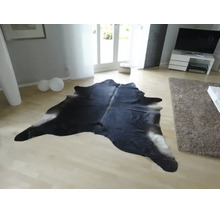 Koberec z hovězí kůže ve světlém moderním obývacím pokoji na světlé dřevěné podlaze.