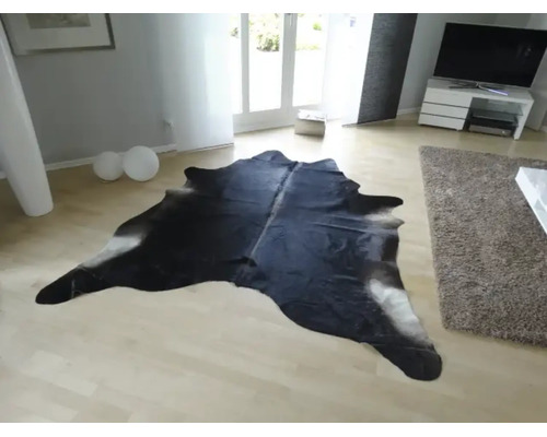 Koberec z hovězí kůže ve světlém moderním obývacím pokoji na světlé dřevěné podlaze.